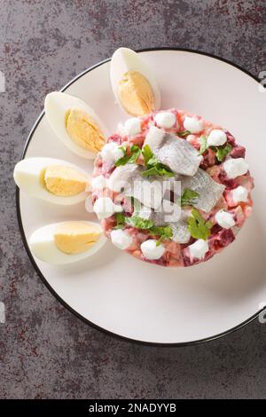 Salade de hareng à la sauce à la crème aigre Sillsallad dans une assiette sur la table. Vue verticale du dessus Banque D'Images