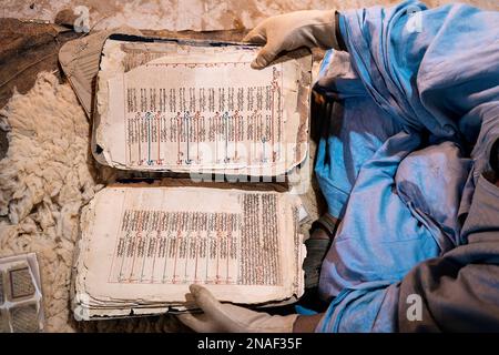 Livres anciens Qur'anic présentés par le bibliothécaire portant des gants Banque D'Images