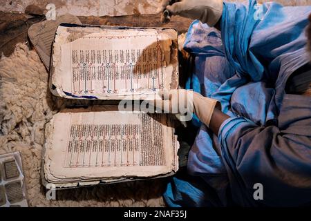 Livres anciens Qur'anic présentés par le bibliothécaire portant des gants Banque D'Images