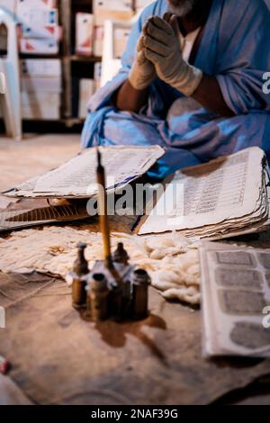 Livres anciens Qur'anic présentés par le bibliothécaire portant des gants Banque D'Images