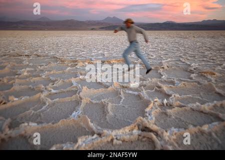 Flou de mouvement d'un homme courant à travers la surface de Salar de Atacama plat de sel au Chili ; désert d'Atacama, Chili Banque D'Images