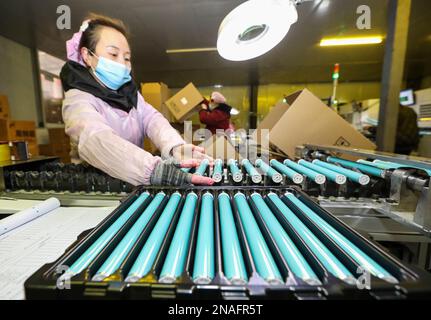 HUAI'AN, CHINE - le 13 FÉVRIER 2023 - Un travailleur traite un tambour de guidage de lumière laser pour une imprimante dans la province de Jiangsu de Huai 'an, en Chine orientale, le 13 février 20 Banque D'Images