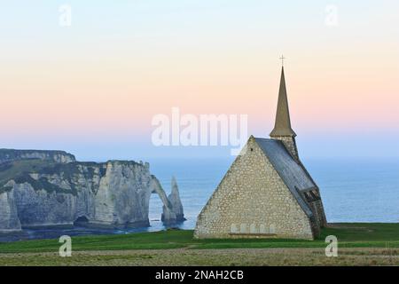 Vue panoramique depuis la Chapelle notre-Dame de la Garde sur la porte d'aval et l'aiguille d'Etretat (Seine-Maritime), Normandie, France au lever du soleil Banque D'Images