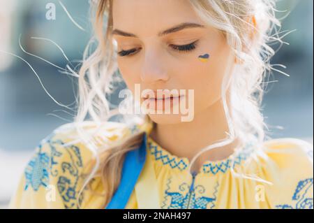 Une jeune fille se tient dans une robe ethnique ukrainienne brodée par temps ensoleillé. Jour de l'indépendance. Banque D'Images