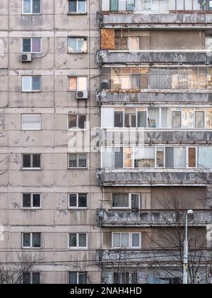 L'immeuble d'appartements de l'époque communiste contre le ciel bleu de Bucarest Roumanie est usé. Un ensemble de logements communistes traditionnels laid Banque D'Images