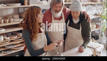 Professeur d'art, poterie et couple senior en classe, conseils d'apprentissage en classe d'art. Jeune femme enseignant le vieil homme et la vieille femme à rouler l'argile, la sculpture et Banque D'Images