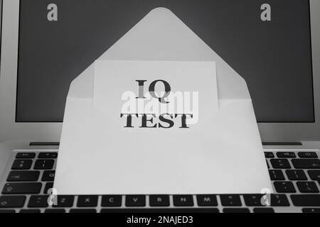 Papier avec test IQ de mots dans une enveloppe sur l'ordinateur portable Banque D'Images