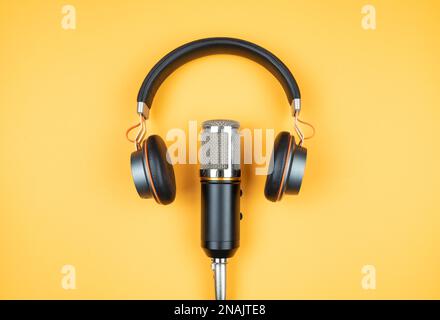 concept de podcasting, directement au-dessus de la vue du casque et du microphone d'enregistrement sur fond orange Banque D'Images