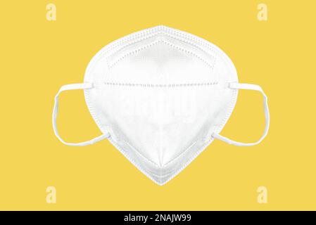 Vue avant du masque FFP2, masque respiratoire isolé sur fond jaune, masque protecteur pour réduire le risque de transmission du coronavirus Covid-19 Banque D'Images