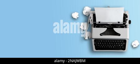 vue de dessus de l'ancienne machine à écrire et des boules de papier froissés sur fond bleu de bureau, écriture ou blog concept Banque D'Images