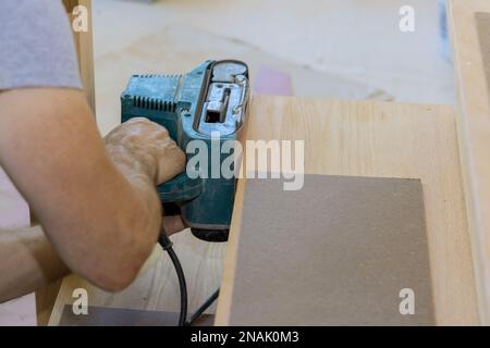 Carpenter travaille avec dans la nouvelle maison meulant escalier en bois Banque D'Images