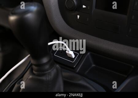 Câble de chargement USB blanc branché à l'intérieur de la voiture moderne Banque D'Images