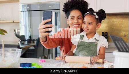 Mère, fille et téléphone selfie tout en cuisinant dans la cuisine, le collage et le plaisir. Apprendre, cuisiner et maman, enfant et 5g mobile pour les médias sociaux, l'image Banque D'Images