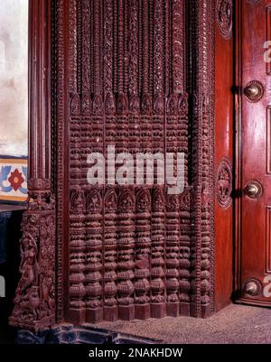 Porte en bois richement sculptée d'une ancienne maison portail à kanadukathan, Chettinad, Tamil Nadu, Inde. 150 ans. Détails des bases du cadre de la porte principale dans Banque D'Images