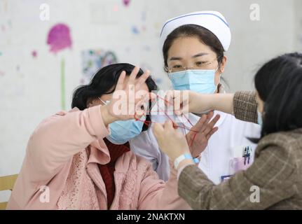 HUAI'AN, CHINE - le 13 FÉVRIER 2023 - Une infirmière dirige un malade mental pour jouer à un jeu appelé « corde de fleur » dans Huai 'an, province de Jiangsu, Chine, Fe Banque D'Images