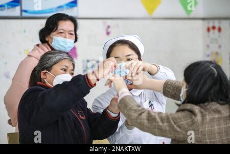 HUAI'AN, CHINE - le 13 FÉVRIER 2023 - Une infirmière dirige un malade mental pour jouer à un jeu appelé « corde de fleur » dans Huai 'an, province de Jiangsu, Chine, Fe Banque D'Images