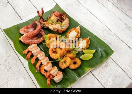 Fruits de mer mélangés cuits. Avec crevettes, calmar, pieuvre, homard et crabe sur la feuille de banane. Gastronomie brésilienne. Banque D'Images