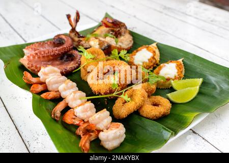 Fruits de mer mélangés cuits. Avec crevettes, calmar, pieuvre, homard et crabe sur la feuille de banane. Gastronomie brésilienne. Banque D'Images