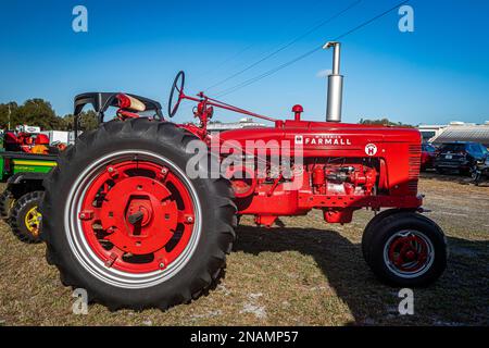 Fort Meade, FL - 24 février 2022 : vue latérale d'une moissonneuse internationale McCormick Farmall Super H 1953 sur un tracteur local Banque D'Images