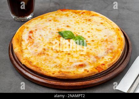 Pizza italienne avec quatre fromages et beaucoup de mozzarella sur une planche à découper Banque D'Images