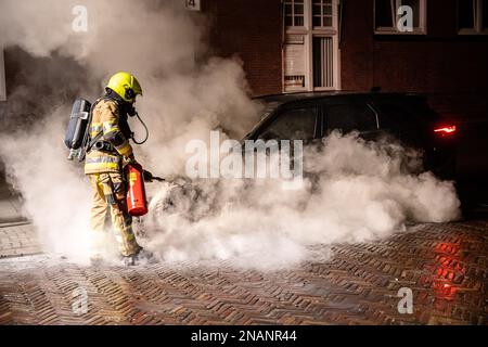 NIMÈGUE, PAYS-BAS - FÉVRIER 13 : incendie de voiture à Nimègue à Sloetstraat. Les pompiers ont été appelés à 01 h 01am pour une brûlure de voiture, à l'arrivée, tout l'avant de la voiture brûlait. Les pompiers ont utilisé de l'eau et un extincteur pour arrêter l'incendie. La voiture qui brûlait était un Range Rover, une voiture hybride avec des batteries dans le coffre. Les pompiers ont déconnecté les batteries dans le coffre pour éviter une combustion spontanée possible. La police ne peut exclure l'incendie criminel comme possibilité d'incendie. 13 février 2023 à Nimègue, pays-Bas (photo de John Beckmann/Orange Pictures) Banque D'Images