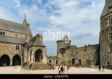 Vue partielle sur le château de la ville française de Vitre par une journée ensoleillée et nuages lumineux avec les touristes dans la cour centrale du château. Banque D'Images