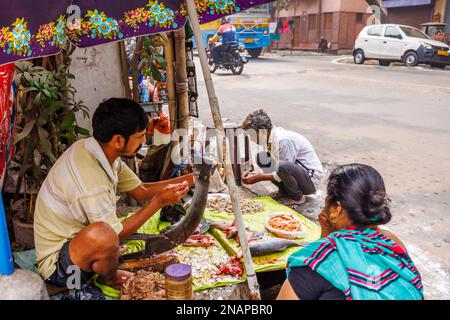 Porte-tout local de rue enlever les balances préparant le poisson à la vente dans un stalle de bord de route typique à Fariapukur, Shyam Bazar, Kolkata, Bengale-Occidental, Inde Banque D'Images