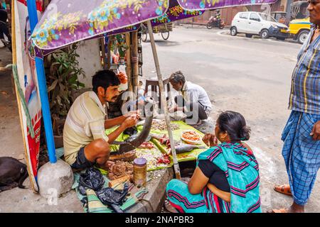 Porte-tout local de rue enlever les balances préparant le poisson à la vente dans un stalle de bord de route typique à Fariapukur, Shyam Bazar, Kolkata, Bengale-Occidental, Inde Banque D'Images