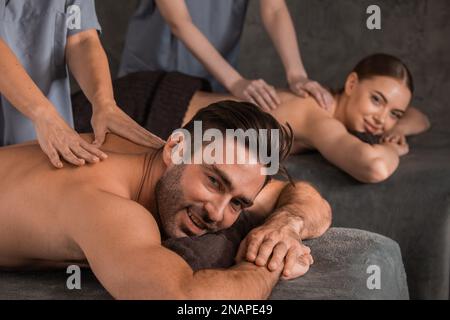 Les conjoints se reposant à un massage thérapeutique relaxant couché souriant au Luxury Spa Resort. Aromathérapie, Beauté, bien-être et détente concept de soin. L bas Banque D'Images