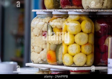 Photo de pots de légumes en conserve, faits maison, sur un marché en Roumanie, en automne, sordide avant l'hiver. Banque D'Images