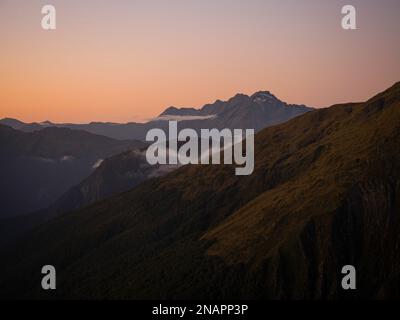 Montagne alpin coucher de soleil sur la vallée, paysage de la nature panorama vu de Mount Armstrong Brewster Hut West Coast Otago Southern Alps South Island New Zealan Banque D'Images