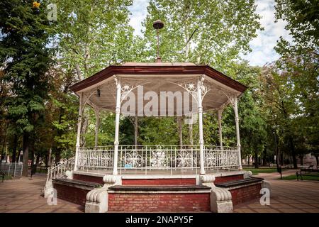 Photo d'un kiosque à musique pendant l'été dans un parc urbain vert. Un kiosque est une structure circulaire, semi-circulaire ou polygonale située dans un parc, un jardin, une jetée Banque D'Images