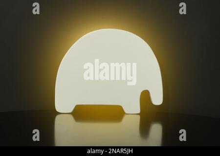 Lampe de nuit lumineuse en forme d'animal sur fond noir Banque D'Images