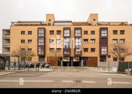 façade d'un immeuble résidentiel moderne construit avec des briques claires et un encadrement en métal rouge Banque D'Images