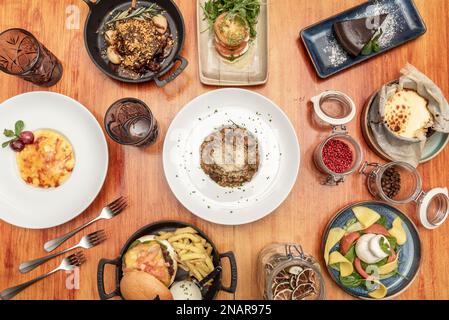 Recettes de cuisine espagnole et italienne avec salade burrata avec pâtes, cheesecake, ragoût de viande et éléments décoratifs assortis Banque D'Images