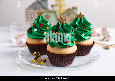 Petits gâteaux en forme d'arbre de Noël sur table blanche Banque D'Images