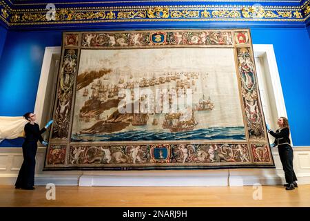 (De gauche à droite) les conservateurs Allison Goudie et Imogen Tedbury de la maison de la reine ajustent la tapisserie de Solebay après son installation dans la chambre de présence du roi à la maison de la reine à Greenwich, dans le sud de Londres. La tapisserie est l'objet vedette de la prochaine exposition, la Van de Veldes: Greenwich, Art et la Mer. Date de la photo: Lundi 13 février 2023. Banque D'Images