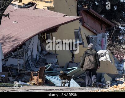 13 février 2023, Turquie, Ördekdede : un homme passe devant les décombres d'un immeuble résidentiel. Dans le petit village, presque toutes les maisons se sont effondrées ou ont été gravement endommagées, et de nombreuses personnes ont perdu la vie. Une semaine après le tremblement de terre en Turquie et en Syrie, le nombre de morts continue d'augmenter. Photo : Boris Roessler/dpa Banque D'Images