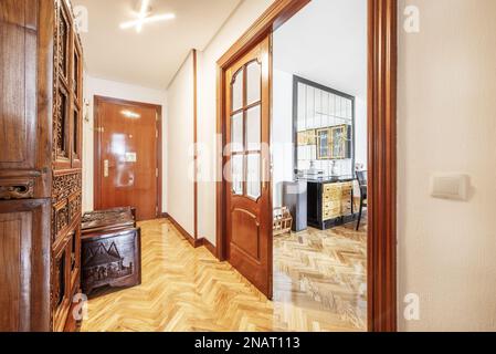 Hall d'entrée d'une maison avec parquet en chêne français verni et portes en sapelli avec fenêtres biseautées Banque D'Images