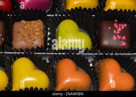 chocolats et pralines colorés en forme de cœur. Banque D'Images