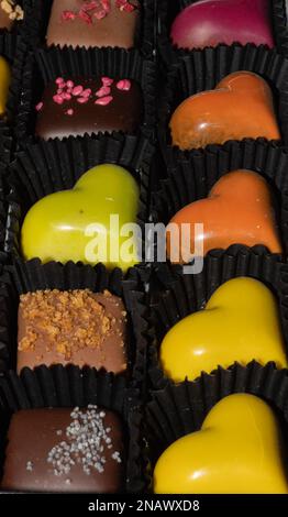 chocolats et pralines colorés en forme de cœur. Banque D'Images