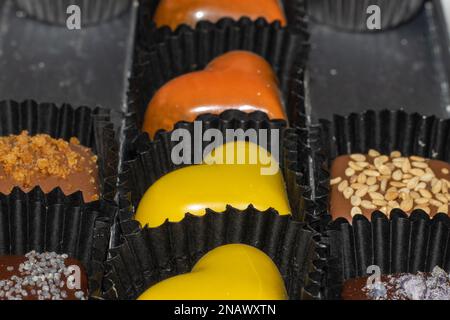 chocolats et pralines colorés en forme de cœur. Banque D'Images