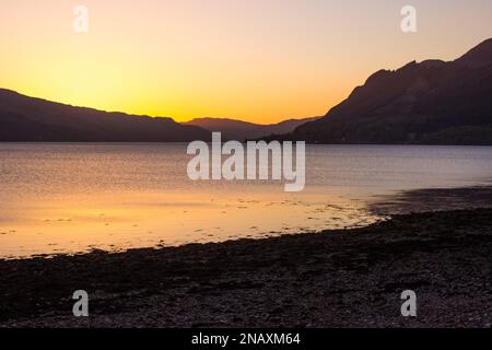 Coucher de soleil doré magique sur les eaux calmes du Loch Duich, en Écosse. Banque D'Images