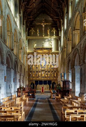 La nef et le choeur de l'abbaye de Wymondham à Norfolk montrant l'architecture normande et le mémorial de guerre de WW1, des reliedos dorés ou un écran d'autel. Banque D'Images