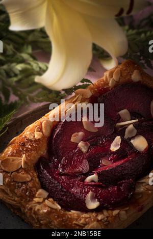 Un tartelet aux prunes fraîchement cuit. La croûte feuilletée et dorée du tartelet est parfaitement cuite avec une texture légèrement croustillante. Banque D'Images