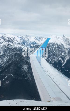 Avion TUI passant des montagnes en quittant l'aéroport d'Innsbruck, Autriche Banque D'Images