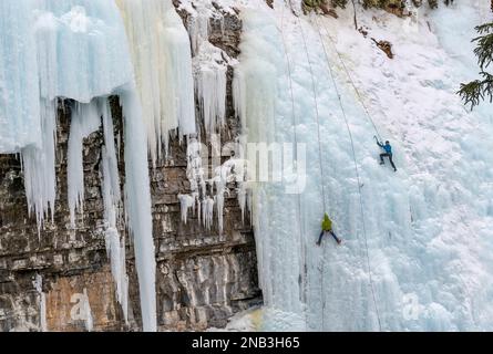 Grimpeurs de glace non reconnaissables sur les chutes surgelées du canyon Johnston, dans le parc national Banff, en Alberta, au Canada Banque D'Images