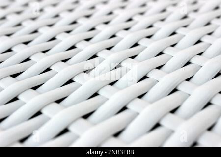 Vue en perspective en gros plan d'une texture de tissage diagonal en osier synthétique blanc, fond propre pour meubles et design Banque D'Images