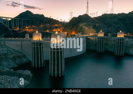 Barrage Hoover au coucher du soleil dans la soirée avec illuminations sans personnes. Barrage Hoover, point de vue. Barrage Hoover et lac Mead dans la région de Las Vegas. Grandes tours d'admission Comstock au barrage Hoover. Banque D'Images