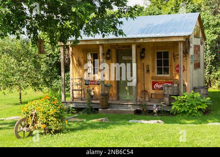 Ancien hangar de rangement en bois de pin de style rustique avec toit en tôle ondulée et décoré de Coca-Cola vintage et de 7up panneaux pour boissons. Banque D'Images